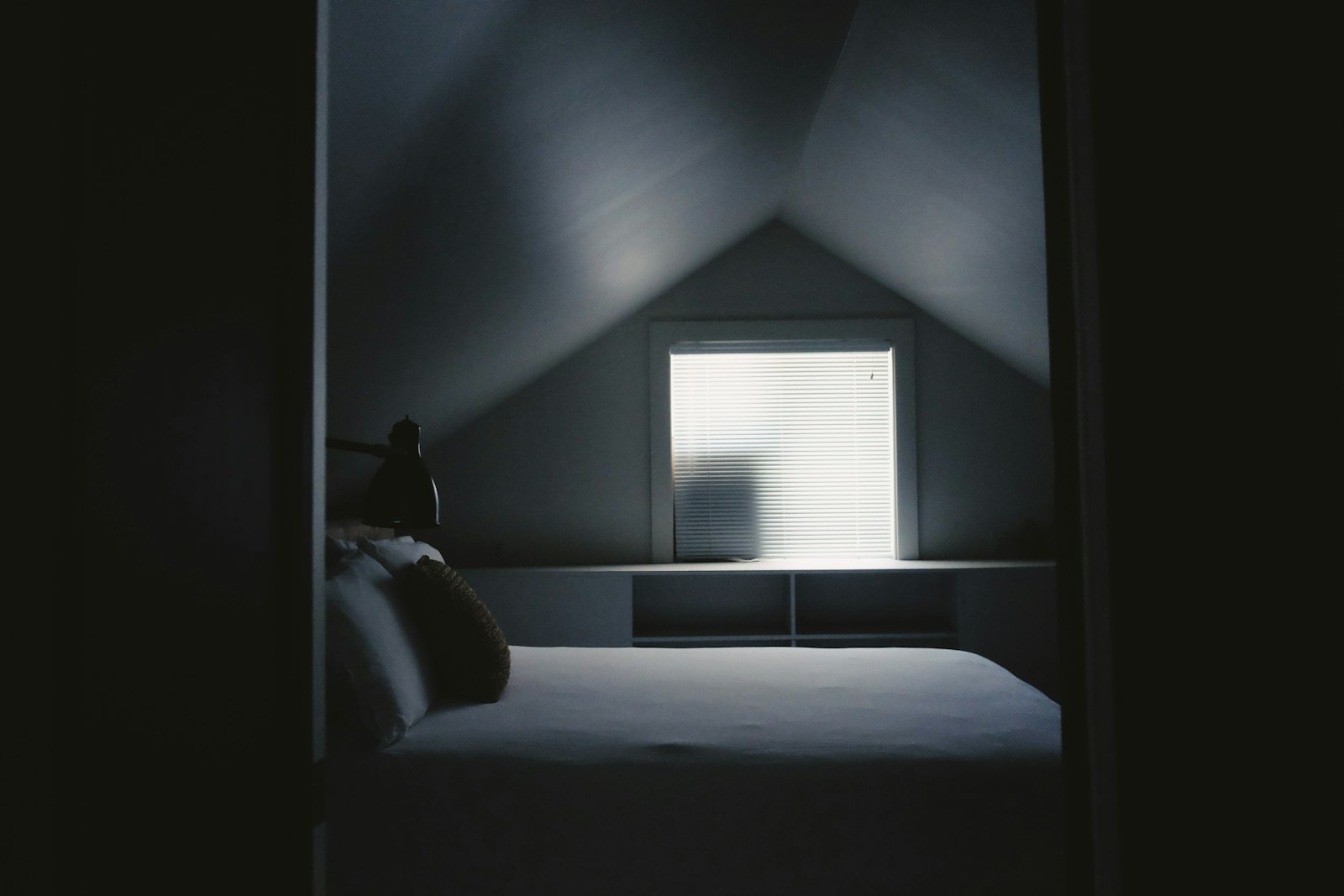 A furnished loft bedroom with a dormer window