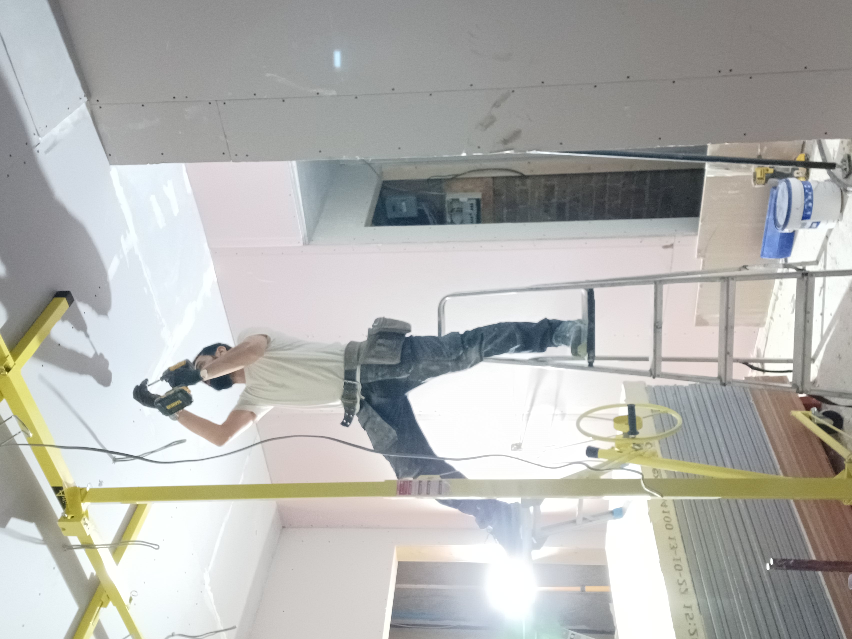 Hands applying plaster to a wall with a trowel